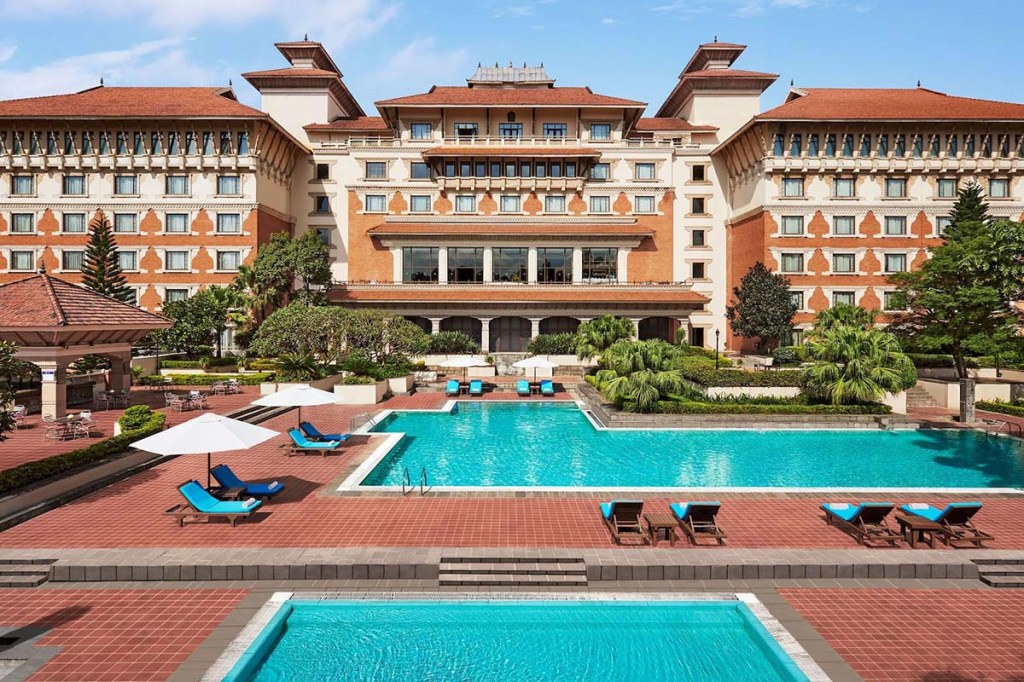 view of a grand hotel and pools in front of it.