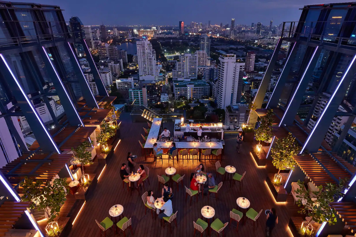 a rooftop restaurant at a hotel in bangkok with a skyline in backgdrop
